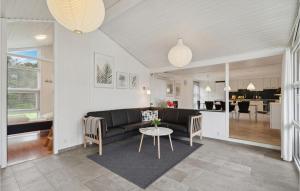 een woonkamer met een bank en een tafel bij Awesome Home In Fars With Sauna in Farsø