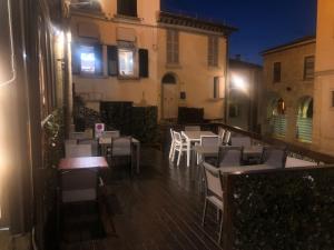 un patio extérieur avec des tables et des chaises et un bâtiment dans l'établissement Hostaria da Lino, à Saint-Marin