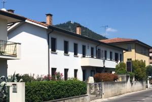 a white building with black windows on a street at Affittacamere Due Mori in Monselice