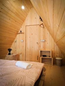 a bedroom with a bed in a wooden room at PUŽMAN Farm Glamping in Radovljica