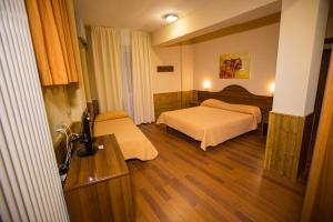 a hotel room with two beds and wooden floors at Hostaria da Lino in San Marino