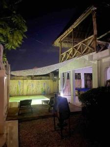 a house at night with chairs and a wall at Villa64 - Afrikanische Villa mit Pool in Nungwi