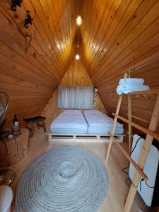 um quarto com uma cama num chalé de madeira em PUŽMAN Farm Glamping em Radovljica