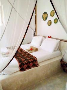 a bed in a tent with a dog laying on it at Villa64 - Afrikanische Villa mit Pool in Nungwi