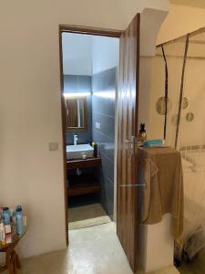 a bathroom with a shower and a sink and a door at Villa64 - Afrikanische Villa mit Pool in Nungwi