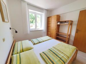 1 dormitorio con 2 camas y ventana en Apartments Mostak, en Baška