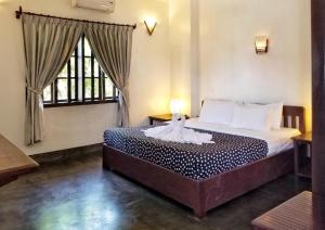 a bedroom with a bed with a lamp on it at Uncle Sam Villa in Siem Reap