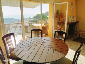 a wooden table and chairs in a room with a window at House Sabina in Lloret de Mar