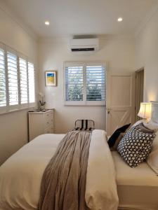 ein Schlafzimmer mit einem großen Bett und zwei Fenstern in der Unterkunft Winemakers Cottage at Treetops Red Hill in Red Hill