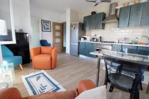 a kitchen with blue cabinets and an orange chair and a table at Casa Anna, Lecrin, Granada in Granada +22 photos