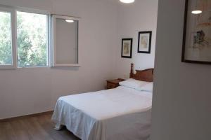 a white bedroom with a bed and a window at Casa Anna, Lecrin, Granada in Granada
