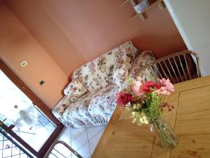 salon z kanapą i wazą kwiatów w obiekcie Holiday-Home-Desenzano w mieście Desenzano del Garda