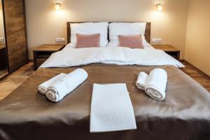 a large bed with towels and pillows on it at Várerdő Vendégház in Kisgyőr