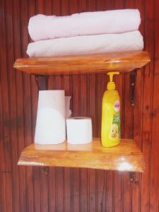 a shelf with towels and a bottle of detergent and toilet paper at Chalet's lake_Bolu Abant _log house in Piroğlu