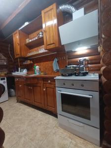 a kitchen with a stove and wooden cabinets at Chalet's lake_Bolu Abant _log house in Piroğlu