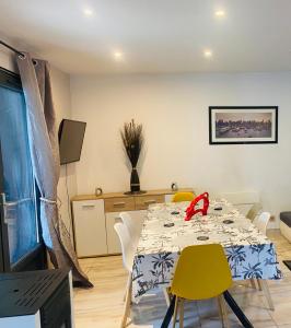 a dining room with a table and yellow chairs at Duplex climatisé avec une terrasse sur jardin in Montmorency +5 photos