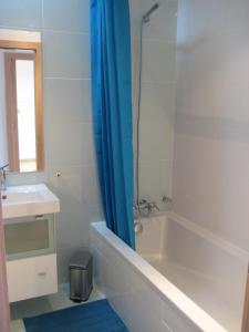 a bathroom with a tub and a sink and a shower at Olaf Nazaré House in Nazaré