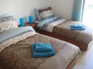 a room with two beds with blue glasses on top of them at Olaf Nazaré House in Nazaré