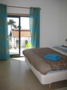 a bedroom with a bed and a large window at Olaf Nazaré House in Nazaré