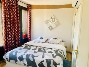 a small bedroom with a bed and a window at Duplex climatisé avec une terrasse sur jardin in Montmorency