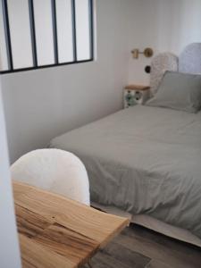 een slaapkamer met een wit bed en een stoel bij L Arancera - Sant Anghjulu - Appartement cosy in Penta-di-Casinca
