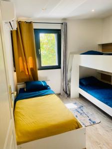 a bedroom with two bunk beds and a window at Duplex climatisé avec une terrasse sur jardin in Montmorency