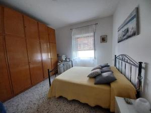 um quarto com uma cama com almofadas e uma janela em A casa di Pissi - apartment em Ravello