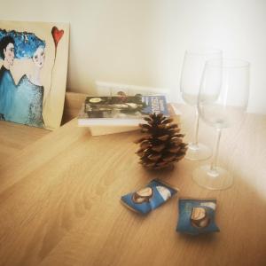 a table with two glasses and a book and a pineapple at Rooms in Vilnius in Vilnius