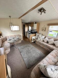 a living room with a couch and a table at 6 berth caravan on Marine holiday park in Rhyl