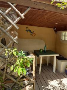 a patio with a table and a bench under a roof at petit studio a la campagne , prévenir entre 3 et 4 heures avant l'arrivée in Gonfaron