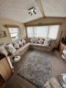 uma sala de estar com um grande sofá num quarto em 6 berth caravan on Marine holiday park em Rhyl