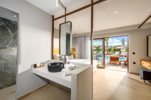a bathroom with a sink and a mirror at Stella Palace Aqua Park Resort in Hersonissos