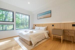 Kaributo的住宿－Kouzan Woods，卧室配有一张床、一张书桌和窗户。