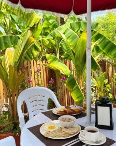 a table with two plates of food and two cups of coffee at Gaskara Guesthouse in Shaviyani Atoll