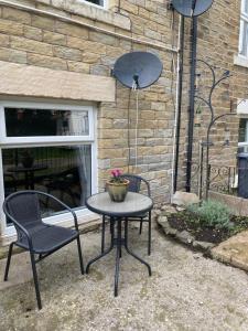 una mesa y dos sillas frente a un edificio en The Cellar on Hornby en Morecambe