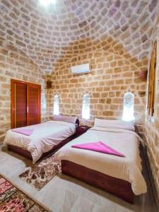 two beds in a room with a brick wall at كمبوند قرية تونس in Tunis