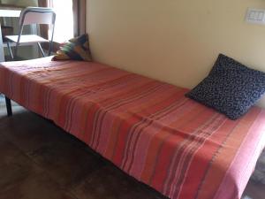 łóżko w pokoju z czerwonym i pomarańczowym kocem w obiekcie Tiny House w mieście Monsampietro Morico