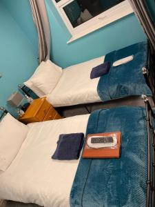 two beds in a room with a remote control at New Bond Hotel in Blackpool