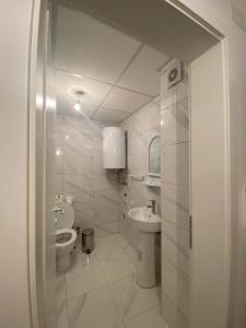 a white bathroom with a toilet and a sink at Apartments Stela Rosa Ohrid in Ohrid
