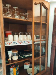 a wooden cabinet with cups and dishes in it at Rucăr Glamping Village in Rucăr