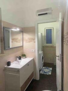 een badkamer met een wastafel en een spiegel bij La Casa Turchina a 3 km da Otranto in Giurdignano