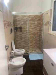 een badkamer met een douche, een toilet en een wastafel bij La Casa Turchina a 3 km da Otranto in Giurdignano