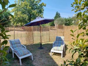two chairs and an umbrella in a yard at Maison de César in Saint-Saturnin-les-Apt +2 photos