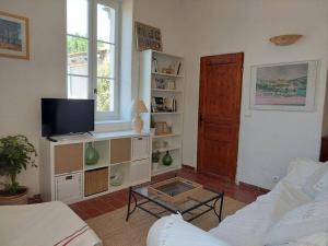 a living room with a couch and a tv at Maison de César in Saint-Saturnin-les-Apt