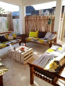 a living room with couches and tables in it at Villa64 - Afrikanische Villa mit Pool in Nungwi