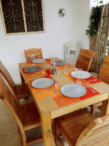 a wooden table with plates and utensils on it at Villa64 - Afrikanische Villa mit Pool in Nungwi
