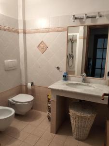een badkamer met een wastafel, een toilet en een spiegel bij Athena soggiorno in San Piero a Sieve