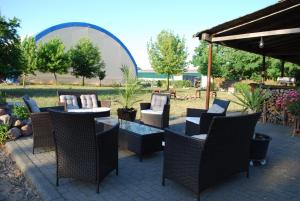 a patio with wicker chairs and tables in a yard at Ruhige-Ferienwohnung-auf-Pferdehof in Dreetz