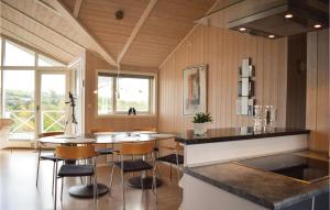 エーベルトフトにあるNice Home In Ebeltoft With House Sea Viewの島付きのキッチン(椅子、テーブル付)