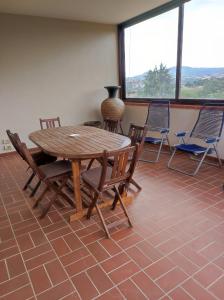 una mesa de madera y sillas en una habitación con ventana en Agriturismo La Carletta, en Preselle